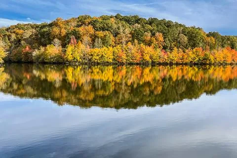 Fall Colors From Hilly Forest Reflect In North Georgia Lake Foto stock
