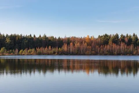 Fall colours of forest reflected in the waters of a lake Stock Photos