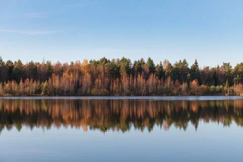 Fall colours of forest reflected in the waters of a lake Stock Photos