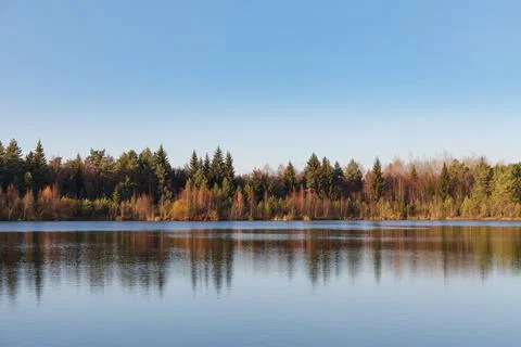 Fall colours of forest reflected in the waters of a lake Stock Photos