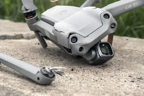 The fall of the drone. a broken flying quadcopter is lying on the asphalt, the Stock Photos