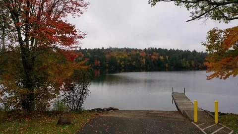 Fall Foliage St George Lake rise shore dock Stock Footage