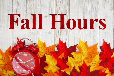 Fall Hours message and alarm clock with autumn leaves Stock Photos