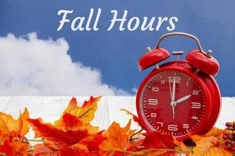 Fall Hours message with fall leaves and alarm clock with sky Stock Photos