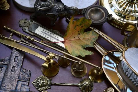 Fall maple leaf and bronze antique items on flea market table Photos