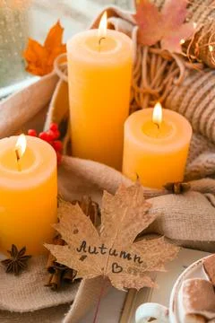 Fall maple leaf with text AUTUMN on Autumn season design concept. Candles on  Stock Photos