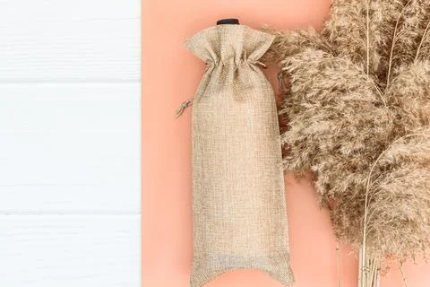 Fall mockup with wine bag blank and dry reeds on white wood background. Stock Photos