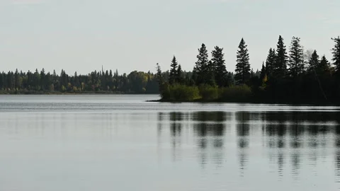 Fall northern lake with small waves creating ripples that distort the reflection Stock Footage 318537877