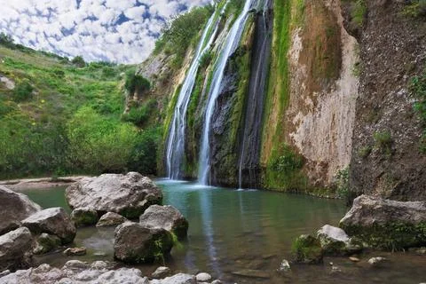The fall in oval pool Three parallel streams of water running down the ste... 库存照片