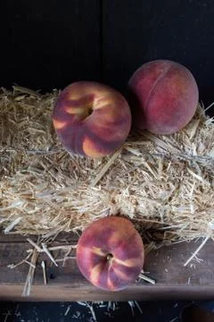 Fall peaches on hay bale rustic setting Stock Photos