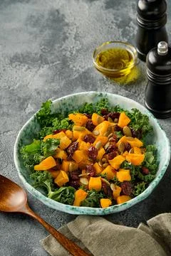 Fall salad with kale, roasted pumpkin, seeds and dried cranberries in bowl. G Stock Photos