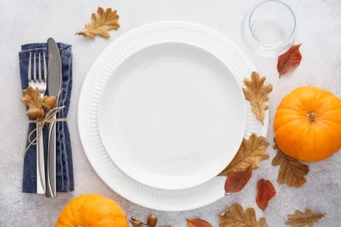Fall season table setting with pumpkins, leaves and cutlery. Stock Photos