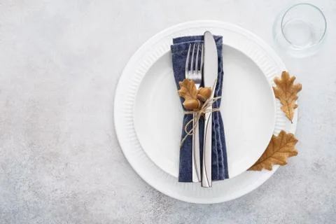 Fall season table setting with white plate and decorated cutlery Stock Photos
