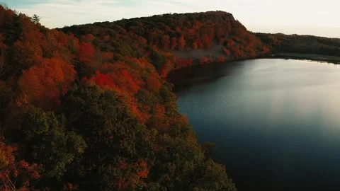 Fall Sunset flying over Trees and Lake with Mountain Top Views - New England Stock Footage 347079616