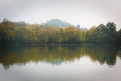 Fall Trees and Lake Reflection on a Foggy Morning Stock Photos