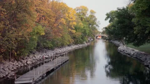 Fall Trees and River with Dock and Stone Bridge Stock Footage 12211653