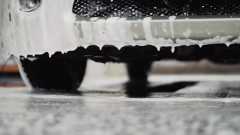 Fall of white foam drops from a car body on a floor of carwash Stock Footage 144674745
