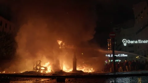 Falla remains burning while firefighters spray water during Las Fallas La Crema Stock-Footage 334296556