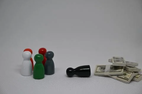 Fallen black pawn next to a stack of money Stock Photos