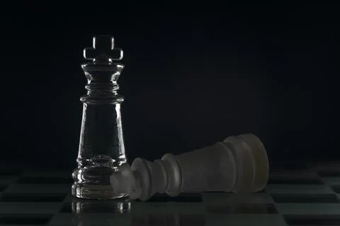 Fallen chess king as a metaphor for fall from power black background copy spa Stock Photos