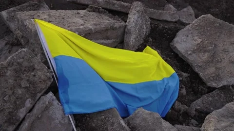 Fallen defeated Ukrainian flag in rubble laying on the ground symbolic of war Stock Footage 172201631