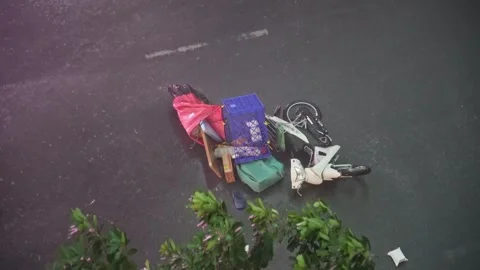 Fallen delivery motorcycle on a wet road during a heavy rainstorm Stockbeeldmateriaal 342403596