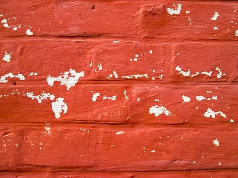 Fallen paint on a red wall. Old building background. Fotos de archivo