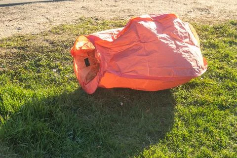 Fallen red sky lantern on green grass environmental pollution Stock Photos