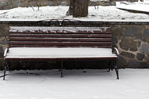Fallen snow on empty park bench in winter Stock Photos