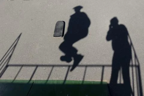 The falling active shadow in motion on the asphalt on the sports field. Enter Stock Photos