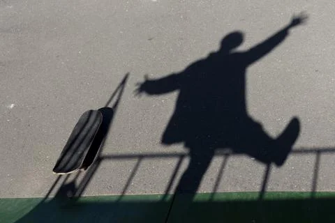 The falling active shadow in motion on the asphalt on the sports field. Enter Foto stock
