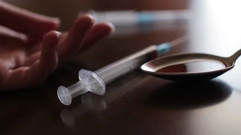 Falling addict hand with syringe Stock Footage 130633443