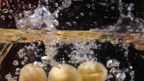 Falling apricot into the water in slow motion Stock Footage 201338932