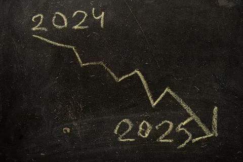 A falling arrow down from the year 2024 to the year 2025 is drawn on a blac.. Stock Photos