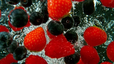 Falling berries into water on a black background. Stock Footage 256241079
