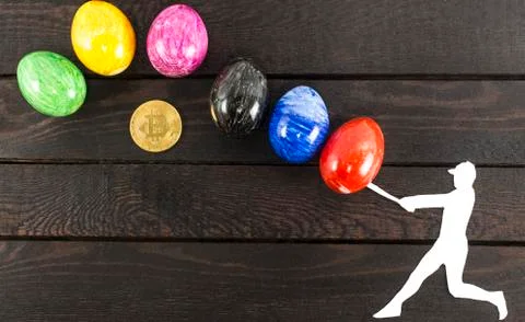 Falling bitcoin concept - baseball player hitting eggs. Stock Photos