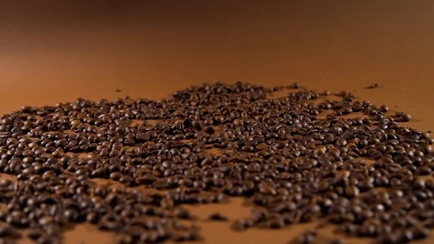 Falling Black Coffee Beans on a Brown Background Stock Footage 126215143
