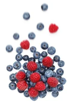 Falling blueberry and raspberry berries isolated on white background Stock Photos