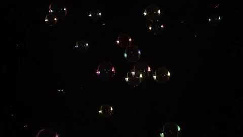 The Falling Bubbles video contains soap bubbles falling through the air on a bla Stock Footage 78178909