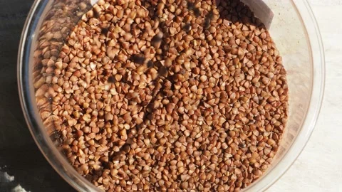 Falling buckwheat into glass jar Stock-Footage 158746399