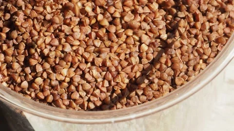Falling buckwheat into glass jar Stock Footage 158747510