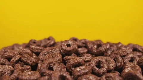 Falling cereal against yellow background Stock Footage 144526962