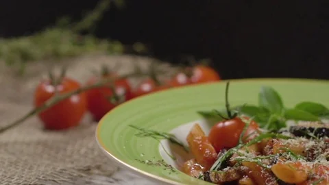 Falling cheese on a penne pasta with cherry tomatoes, aubergines, decorated Видео 75243644