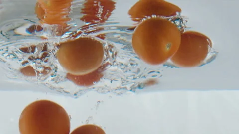 Falling cherry tomatoes in an aquarium in slow motion 120 fps Stock Footage 101945087