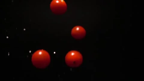 Falling cherry tomatoes isolated on black background, slow motion Vídeo Stock 252406142