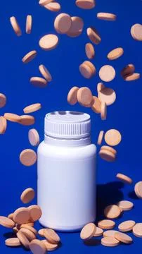 Falling Chewable Vitamin C Tablets with Bottle on Blue Background Stock Photos