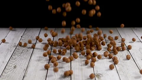 Falling chocolate balls on wooden table. Slow motion Stock Footage 140233152