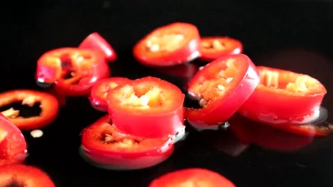 Falling chopped red chilli pepper with water splash Video stock 136120237