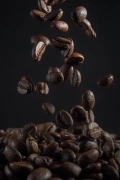 Falling coffee beans on the dark background Stock Photos
