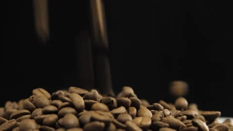 Falling coffee beans on dark surface close up. Spilling roasted coffee beans Stock Footage 149805417